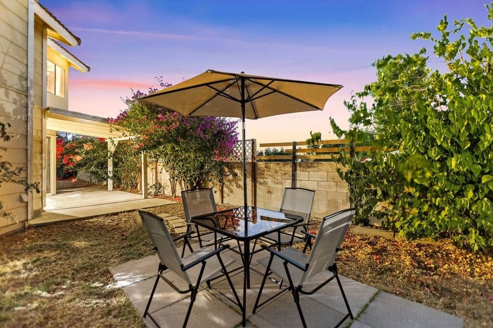 Dine alfresco under the umbrella with a cozy table setup - perfect for relaxing meals.