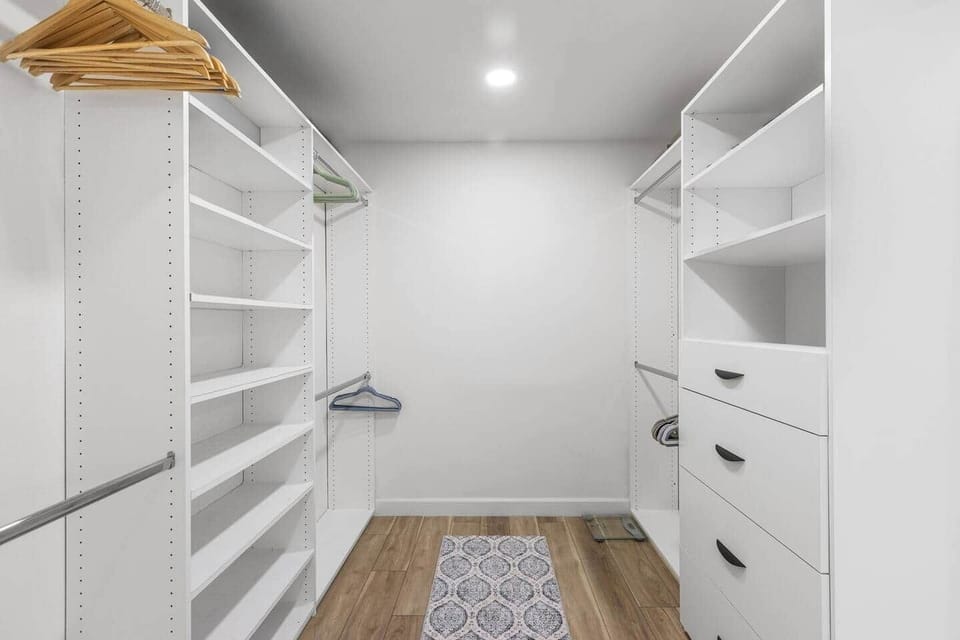 This walk in closet offers built in shelves and plenty of hanging space to stay organized.