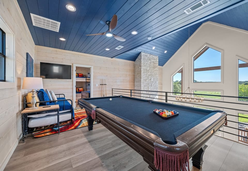 Game room with pool table, cozy seating, and TV. Great for relaxing and hanging out with friends or family.