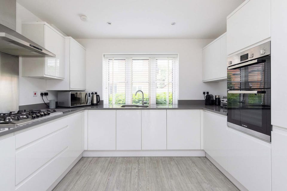 The bright and spacious kitchen is fully equipped with modern appliances, including a double oven and plenty of countertop space.