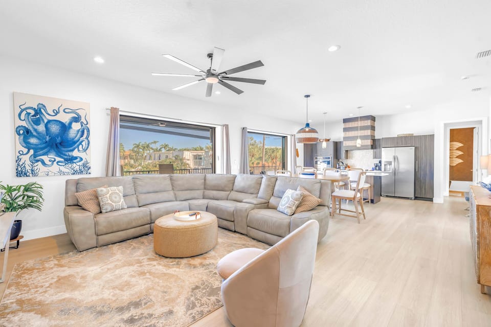 Living area spacious and sunny, opens to balcony with tropical view.