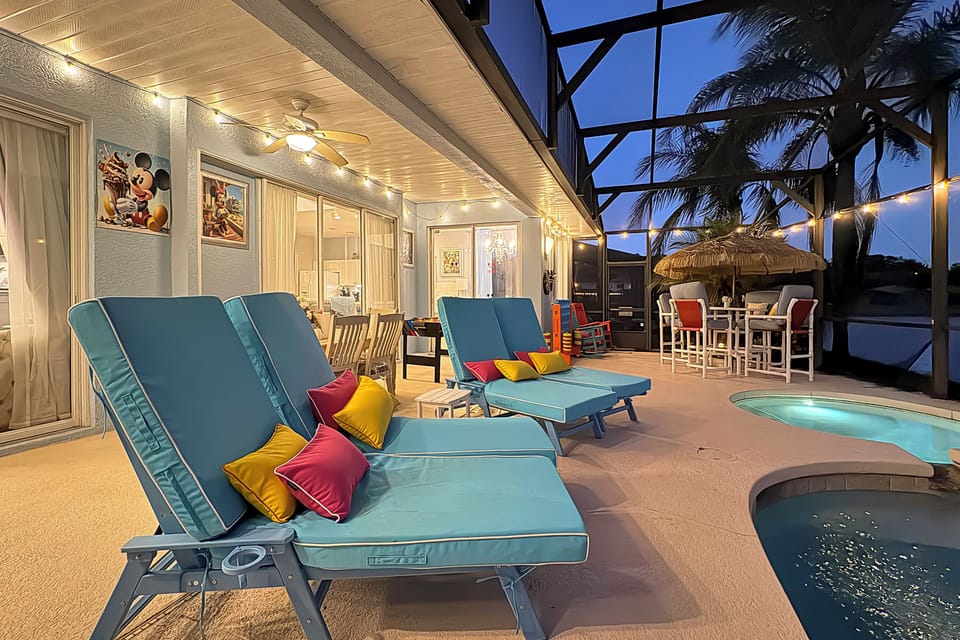 Spacious Poolside Patio – Plenty of space for everyone with multiple loungers, palm trees, and colorful accents that set the tone for a true vacation vibe.