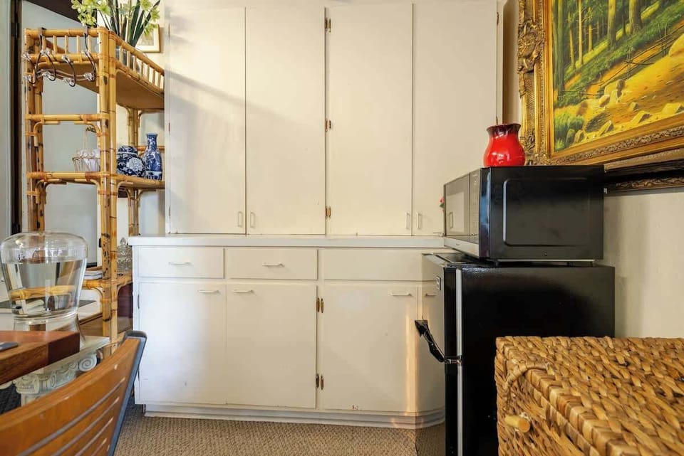 Convenient kitchenette area with storage cabinets and a mini fridge for added comfort.