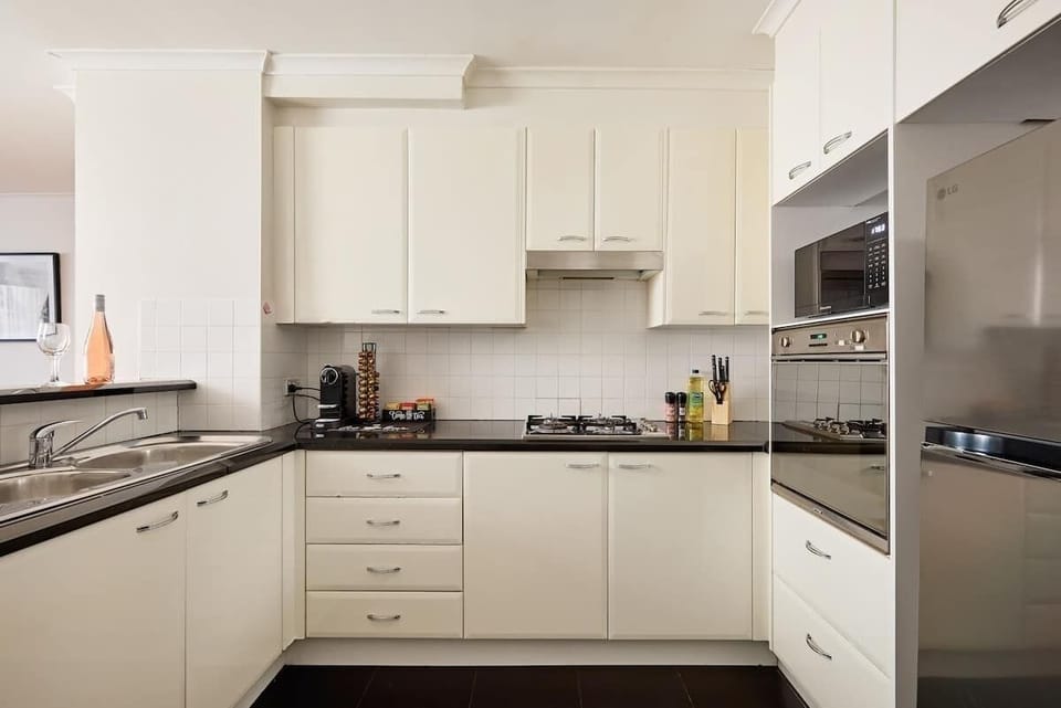 Fully equipped kitchen featuring stainless steel appliances, gas cooktop, oven, microwave, and ample storage. Everything needed for convenient self-catering during your Sydney stay.
