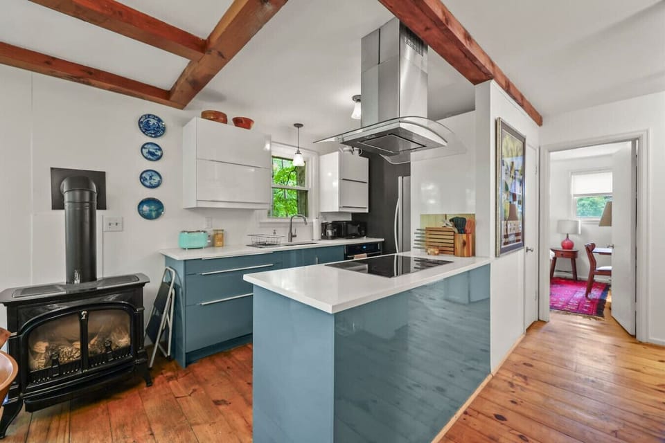 Modern kitchen with gas stove and wood floors.