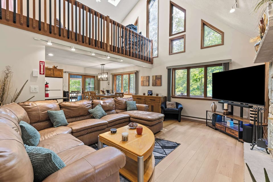 Step into your mountain hub. Vaulted ceilings, skylights, and a huge sectional open to the dining/kitchen, perfect base for Poconos adventures near Lake Wallenpaupack and Kalahari.
