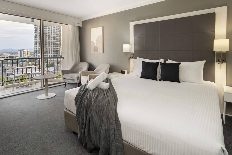 Rest easy in the plush queen bed dressed in soft linens, surrounded by a calming neutral palette for a tranquil night’s sleep.