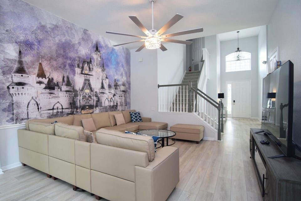 Stylish living area with L-shaped sofa, Smart TV, sliding doors to pool deck