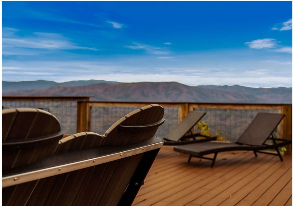 Deck seating area with comfortable chairs and mountain scenery