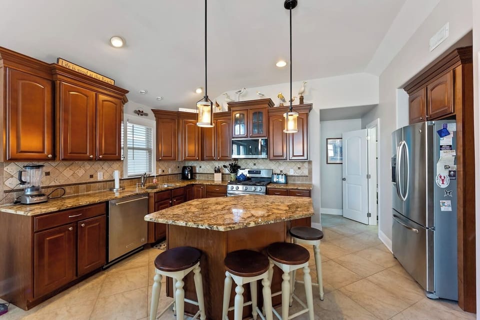 Full kitchen with stainless steel appliances, large island for additional seating, ample prep space and separate beverage refrigerator. 