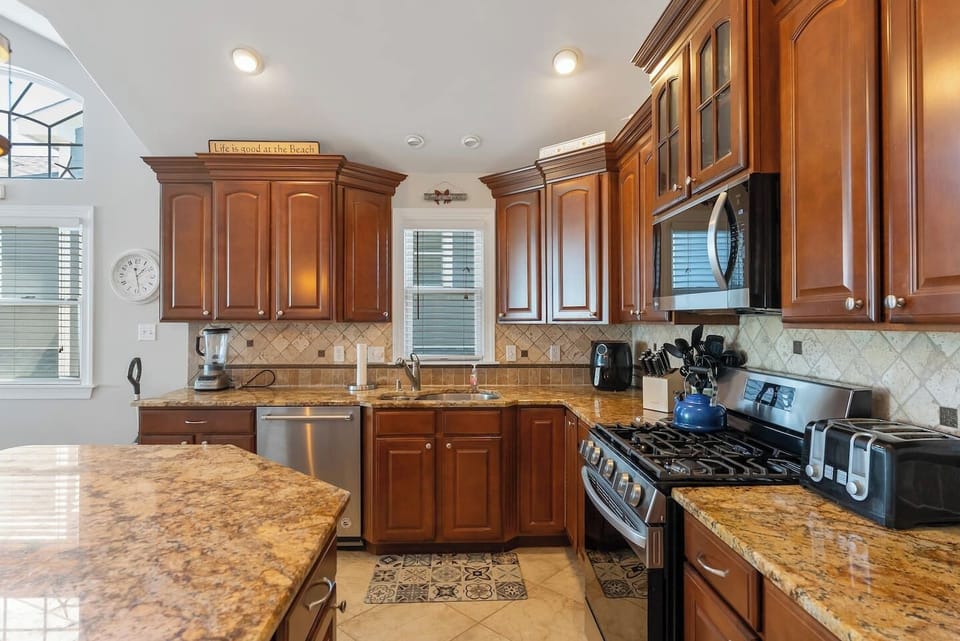 Full kitchen with stainless steel appliances, large island for additional seating, ample prep space and separate beverage refrigerator. 
