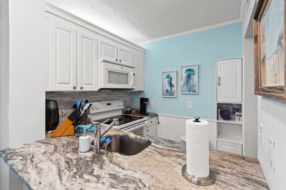 Kitchen bar with granite countertops and beautifully decorated coastally themed Fully Stocked Kitchen
