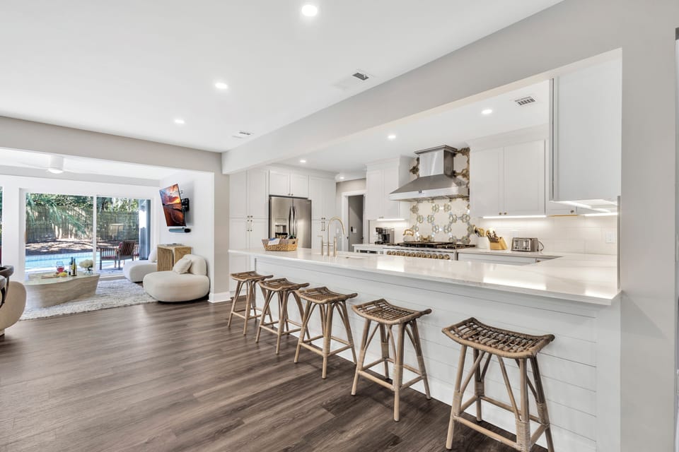 This stunning kitchen overlooks the large dining space, boasts views of the private pool, and is a dream for culinary delights and gatherings