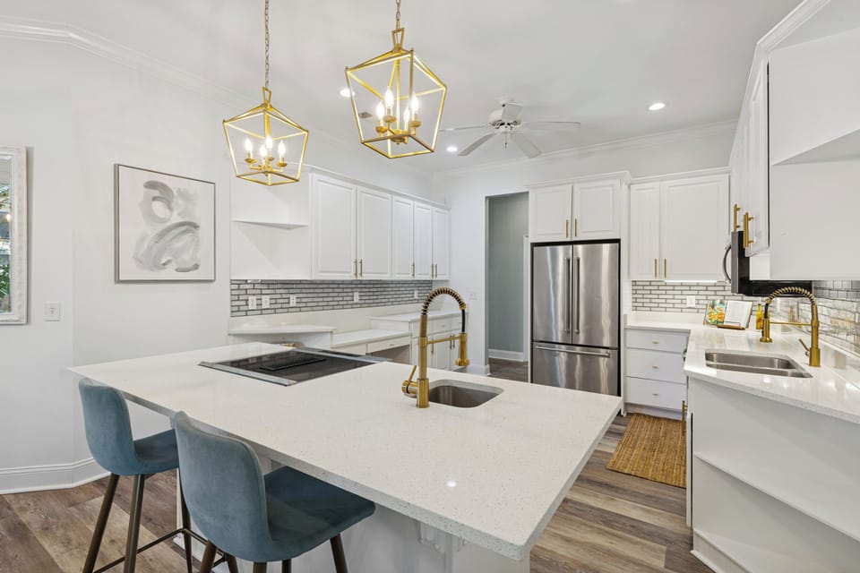 Fully equipped with double sinks, an electric cooktop, a large fridge, and ample counter space