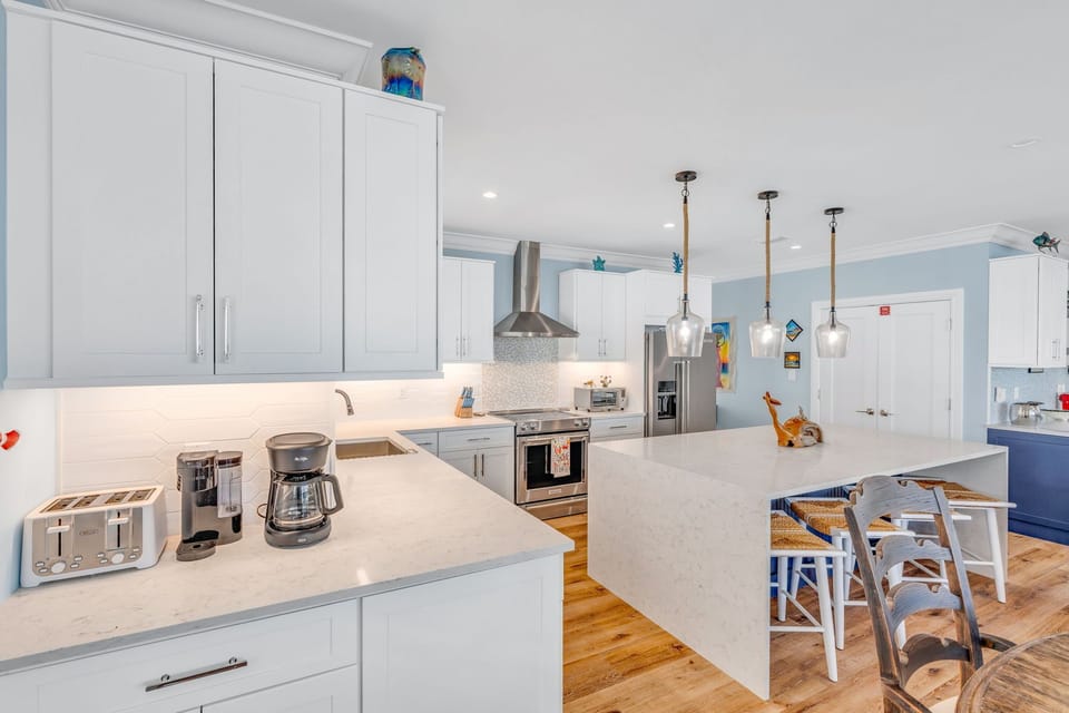 Enjoy morning coffee or a relaxed brunch with your family in the open-concept kitchen at Emerald Shores. Equipped with a Keurig Duo and spacious island seating, it blends convenience with coastal elegance.