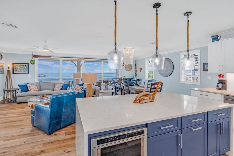 Prepare gourmet meals in this fully equipped, modern kitchen featuring stainless steel appliances, island seating for four, and sweeping Gulf views. Perfect for family vacations or group retreats.