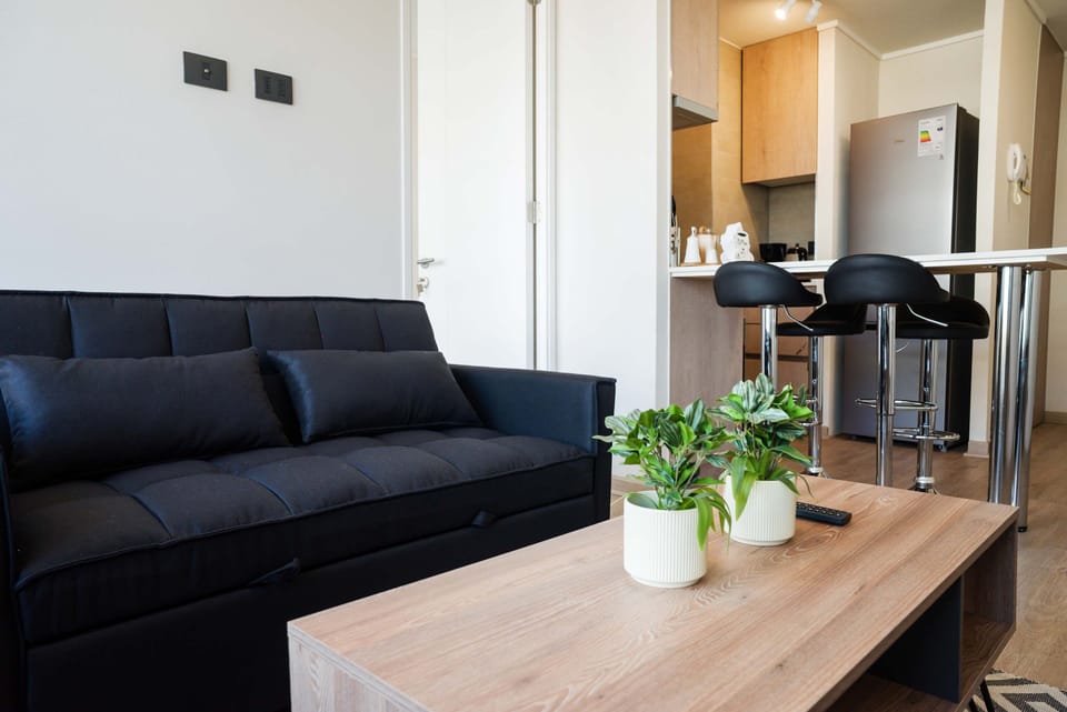 Cozy living area with modern furnishings and a sleek kitchen, perfect for relaxing after exploring the city.