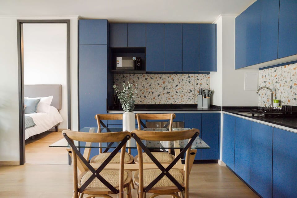 Stylish kitchen with blue cabinetry and terrazzo backsplash, ideal for cozy meals and gatherings.
