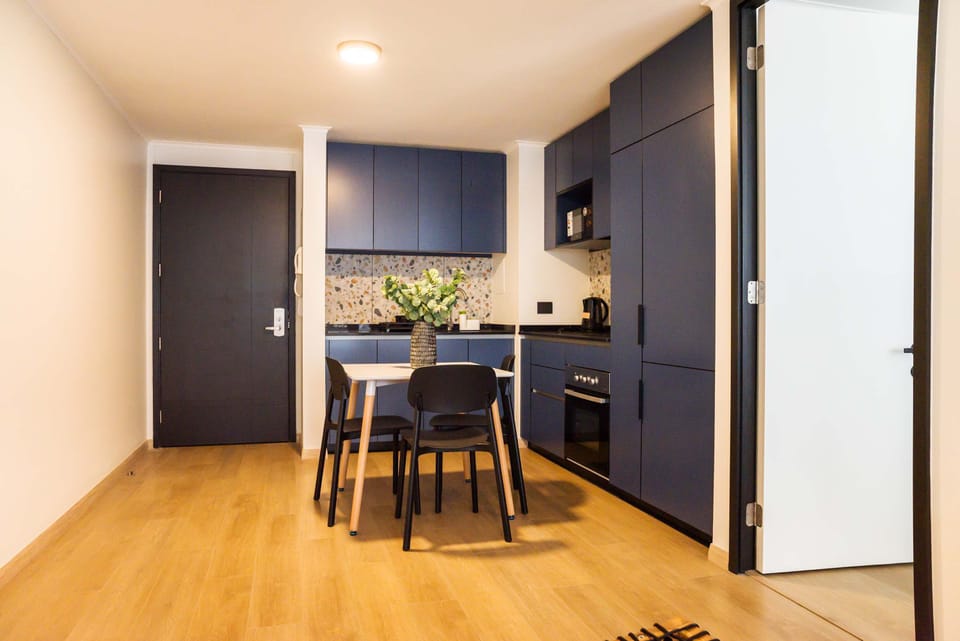 Modern kitchen with stylish blue cabinets and cozy dining space, perfect for intimate meals.