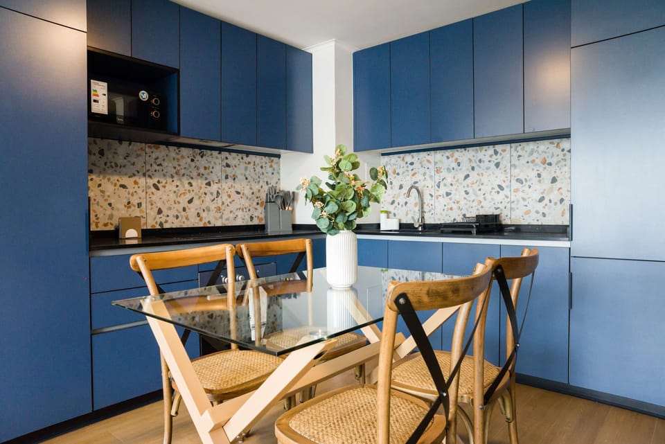Sleek kitchen with blue cabinets and terrazzo backsplash, ideal for stylish cooking and dining.