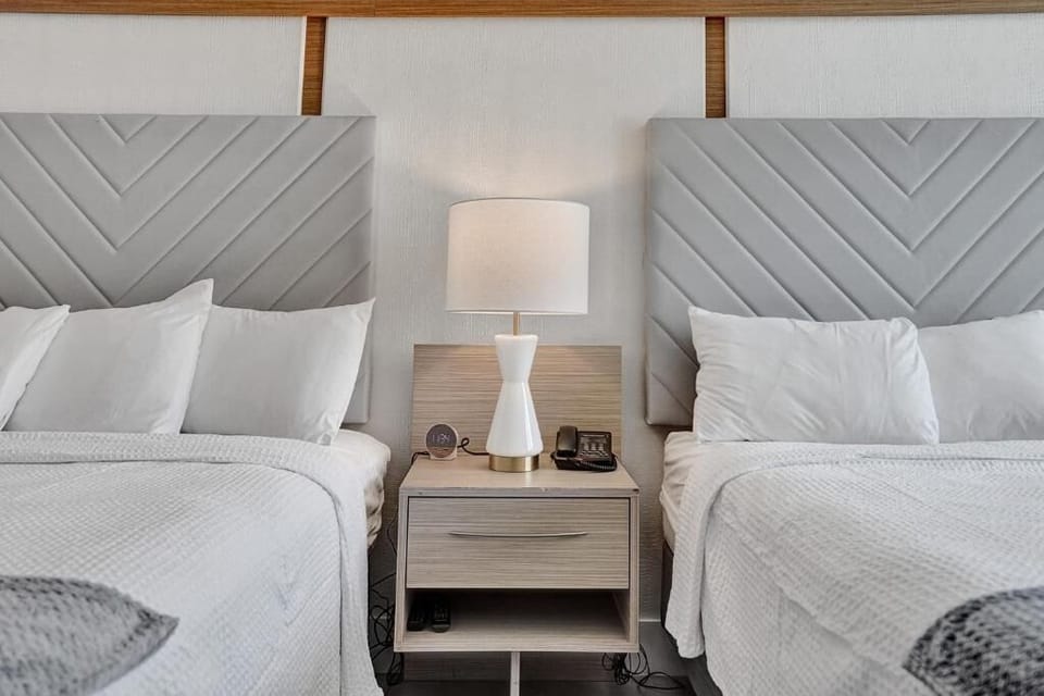 Sink into crisp linens beside soft lighting and calm tones.