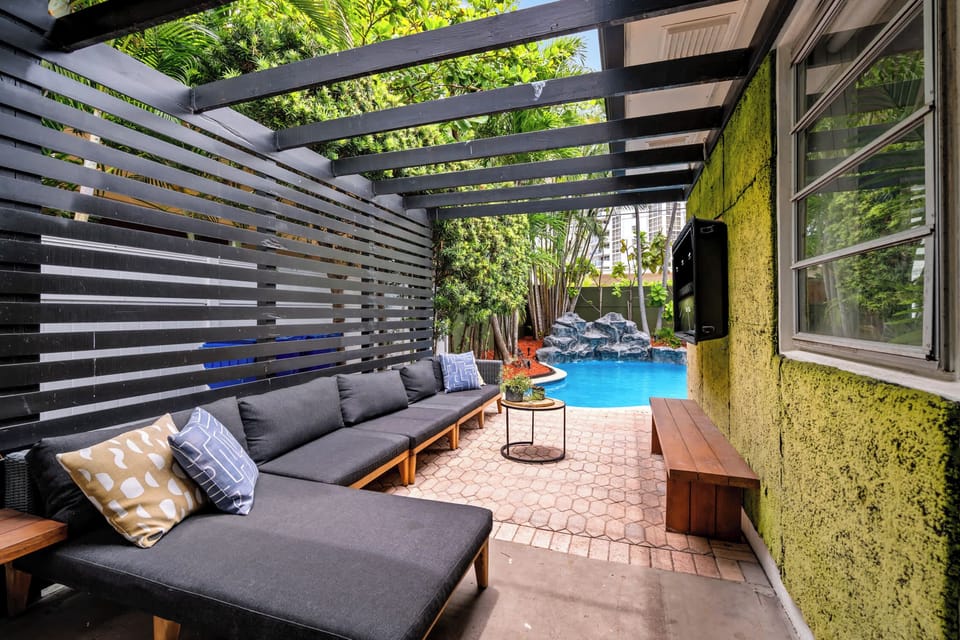 Covered outdoor lounge with sectional, opening to the pool.