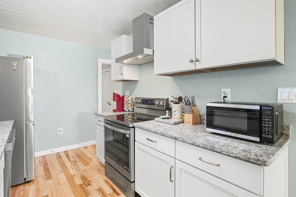 Kitchen: Gourmet kitchen with granite countertops, stainless steel appliances, and a commercial-grade vented hood.