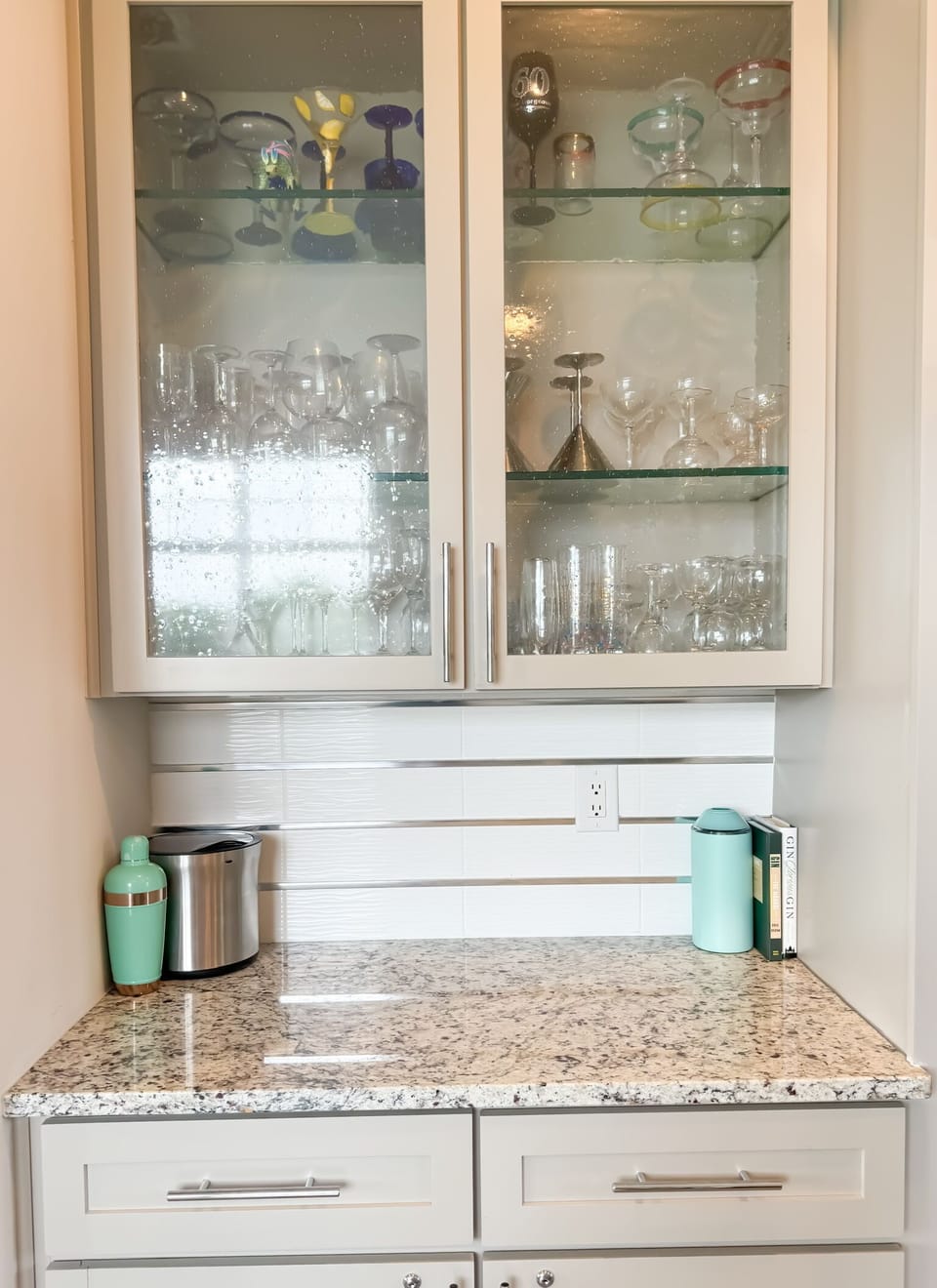 Dry bar fully stocked with glassware and barware.