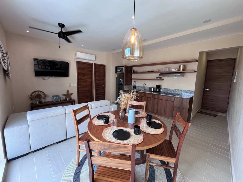 Share meals at the inviting dining table, connecting to the cozy living space.
