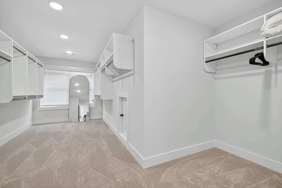 Keep clothes & bags neatly organized in the massive primary suite’s walk-in closet​