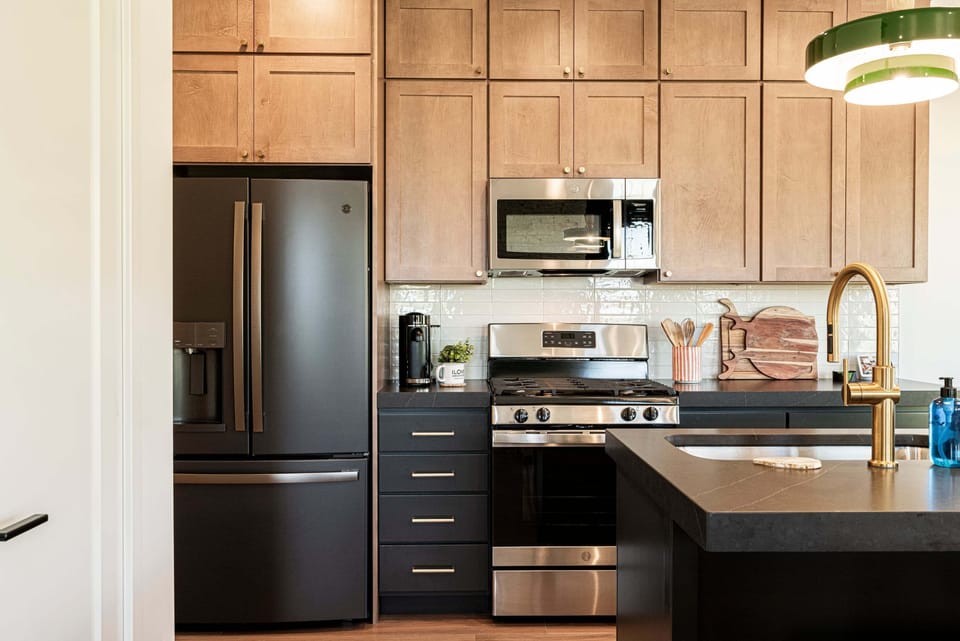 Black stainless refrigerator with water and ice on the door