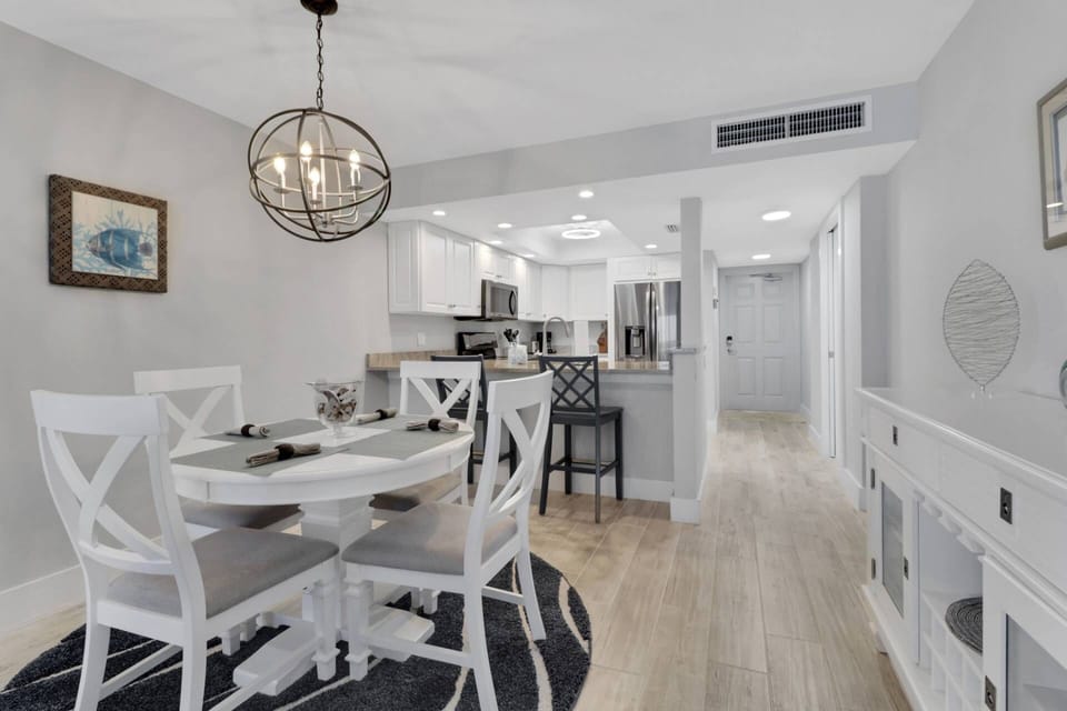 A table for 4 is in the dining area and a pair of barstools for 2 sit at the kitchen pass-through bar.