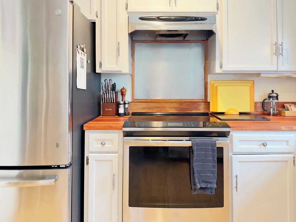 Cook comfortably with a full-size electric range, sharp knives, and solid prep space—everything set up for easy home-style meals, from quick breakfasts to relaxed dinners together.