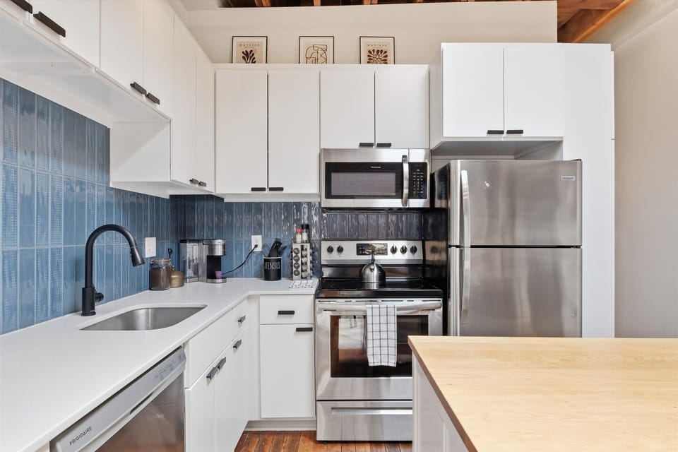 Fully stocked kitchen with stainless steel appliances and an enhanced coffee bar.
