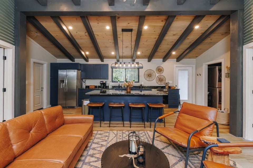 This space nails the “cook, sip, chill” trifecta. Grab a seat at the island, test your Gordon Ramsay skills, or just sprawl on the leather sofa pretending to “supervise.” Vaulted ceilings and warm tones make even takeout feel gourmet here.