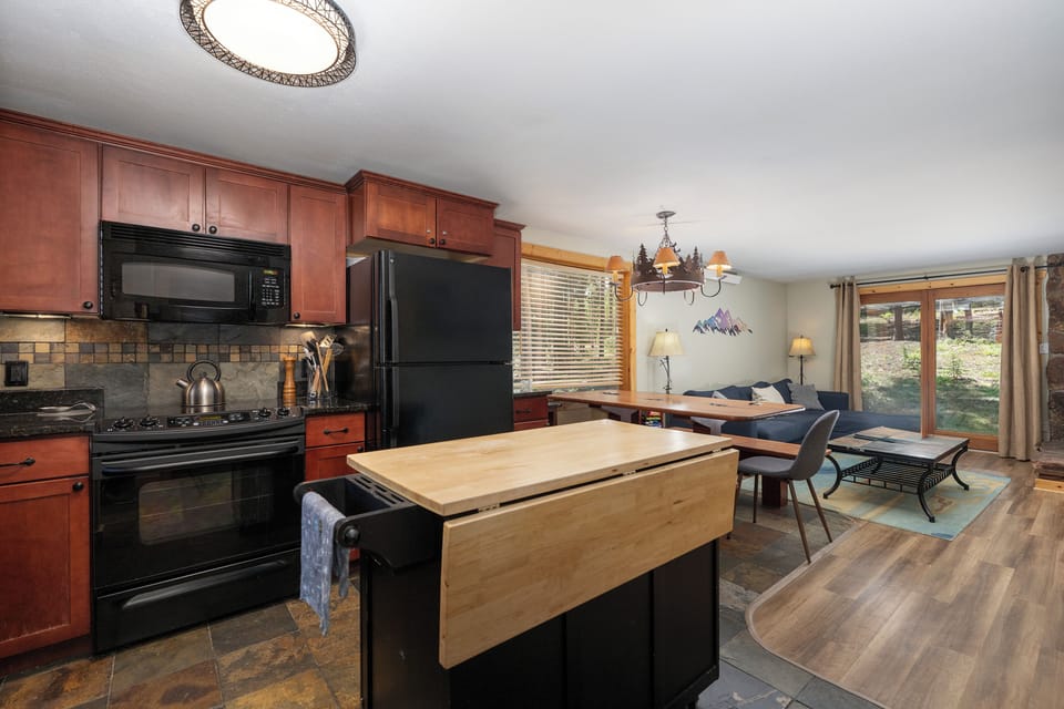 Your fully-equipped kitchen flows seamlessly into the cozy living area, perfect for gathering after mountain adventures.