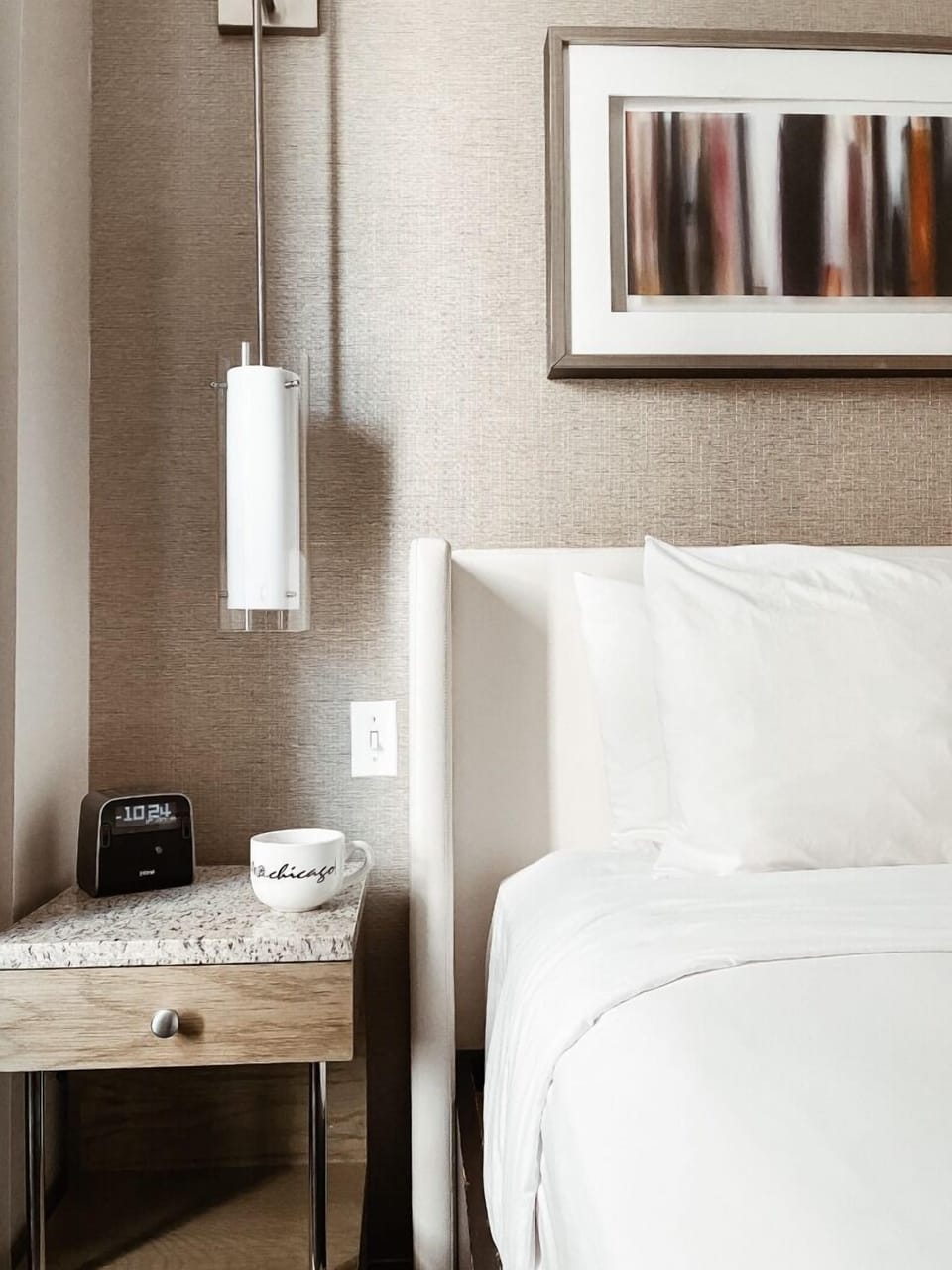 Unwind in crisp linens beside sleek lighting and bedside comforts.