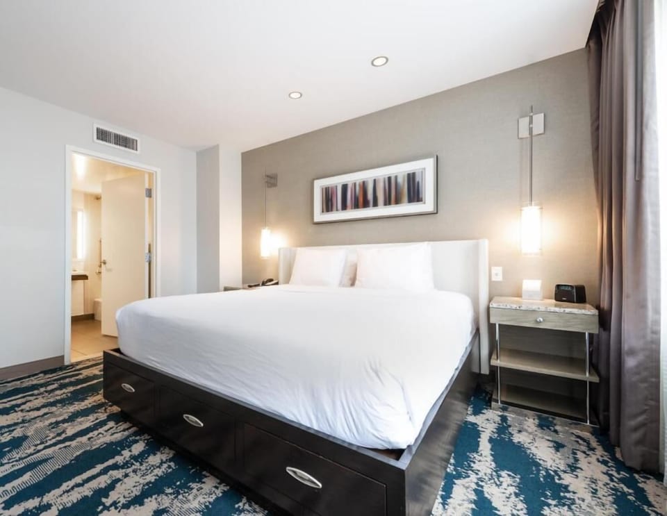 Unwind on crisp linens in a bright, modern room.