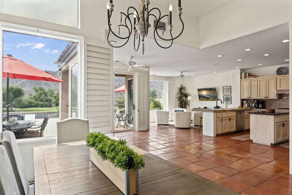 Sunlit living area w/ floor-to-ceiling shutters opening wide to the patio