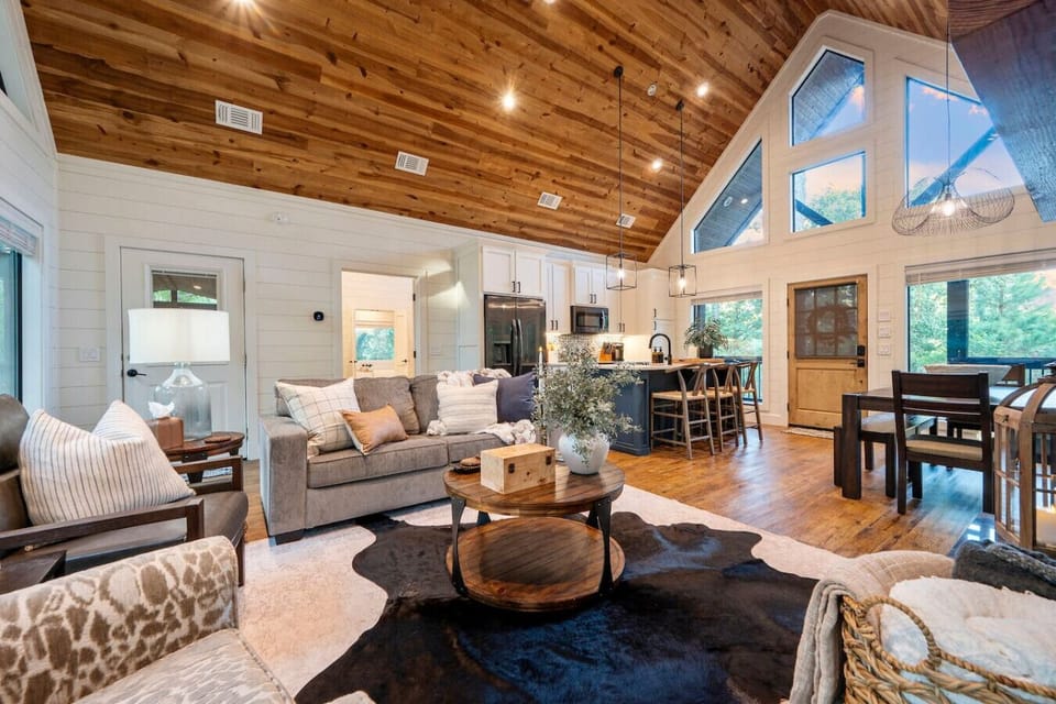 This open-concept living space is basically designed to keep everyone together—whether you`re cooking, eating, or just lounging by the fire while soaking in those cathedral ceilings and mountain views.