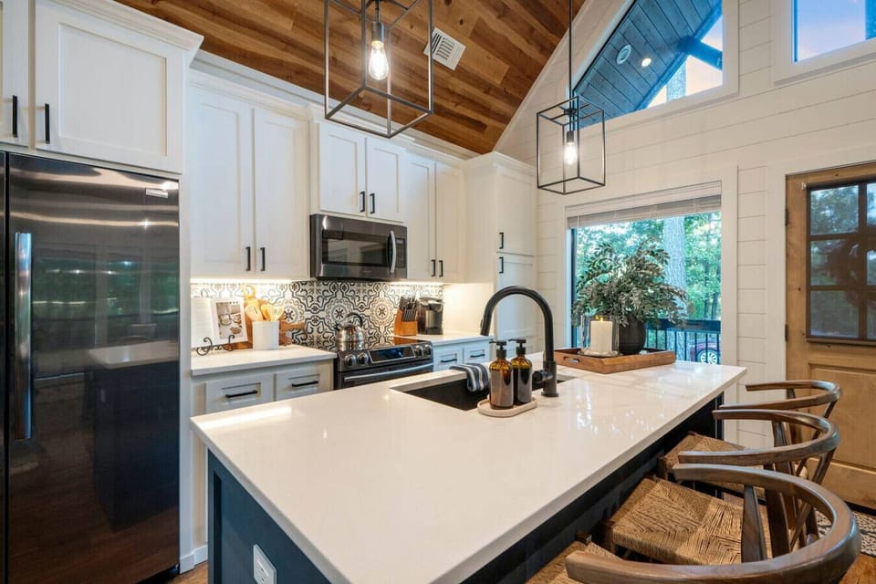 This kitchen is where you`ll actually want to spend time cooking with those soaring ceilings, natural light flooding in, and a layout that somehow manages to be both totally functional and seriously gorgeous.