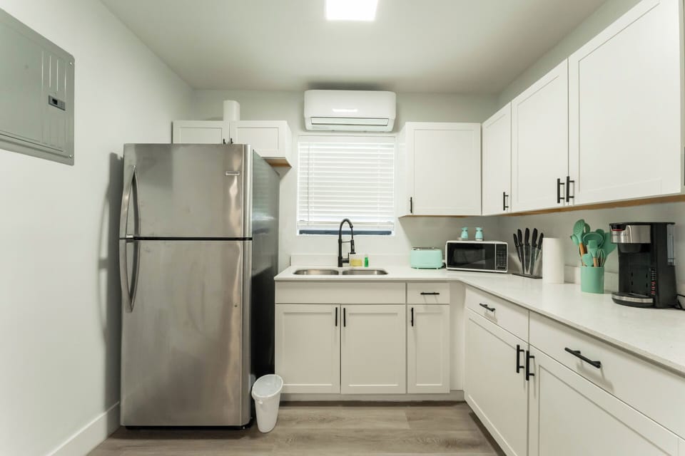 Spacious layout with full-size fridge, sink, and bright natural light.
