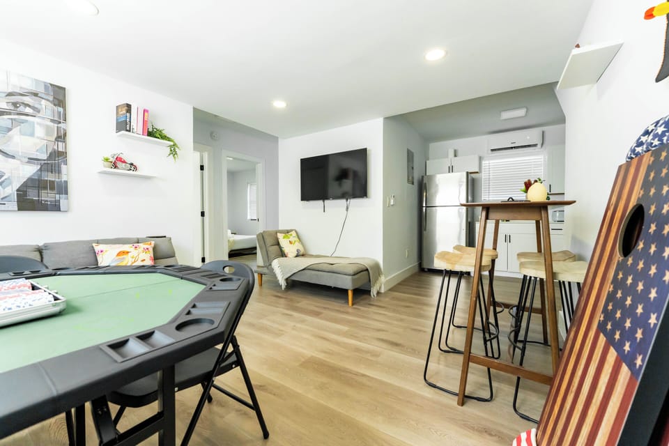 Bright open-concept living area with Smart TV, lounge space, and dining bar.