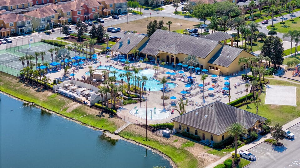 Aerial view of a vibrant community clubhouse with a large pool, splash pad