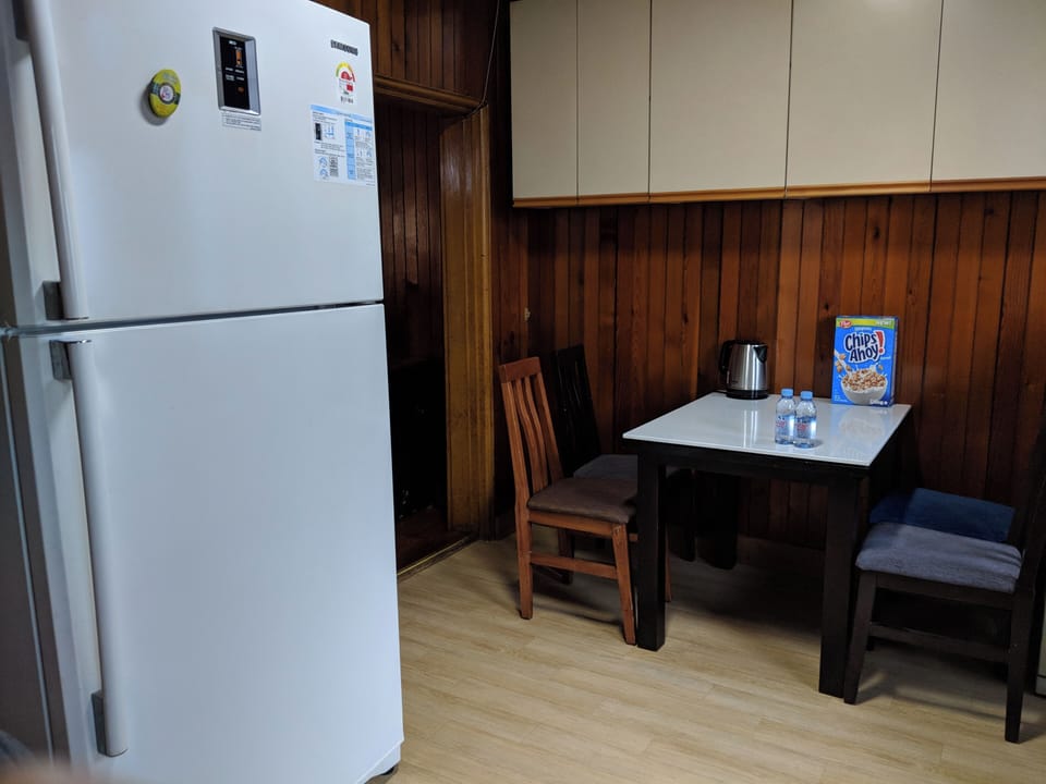 Kitchen area with expandable folding dining table. Kitchenware provided.