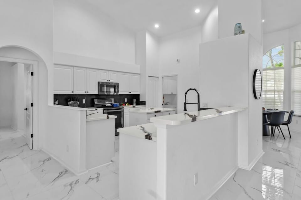 Sleek chef's kitchen boasting elegant countertops, stainless appliances, and breakfast bar—perfect for families and foodies alike