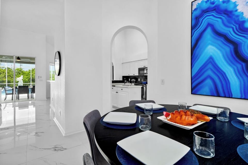 Bright and stylish, this dining area features modern black seating, marble-look flooring, and sunshine spilling in—an inviting place to gather for meals, play games, or host friends with ease.