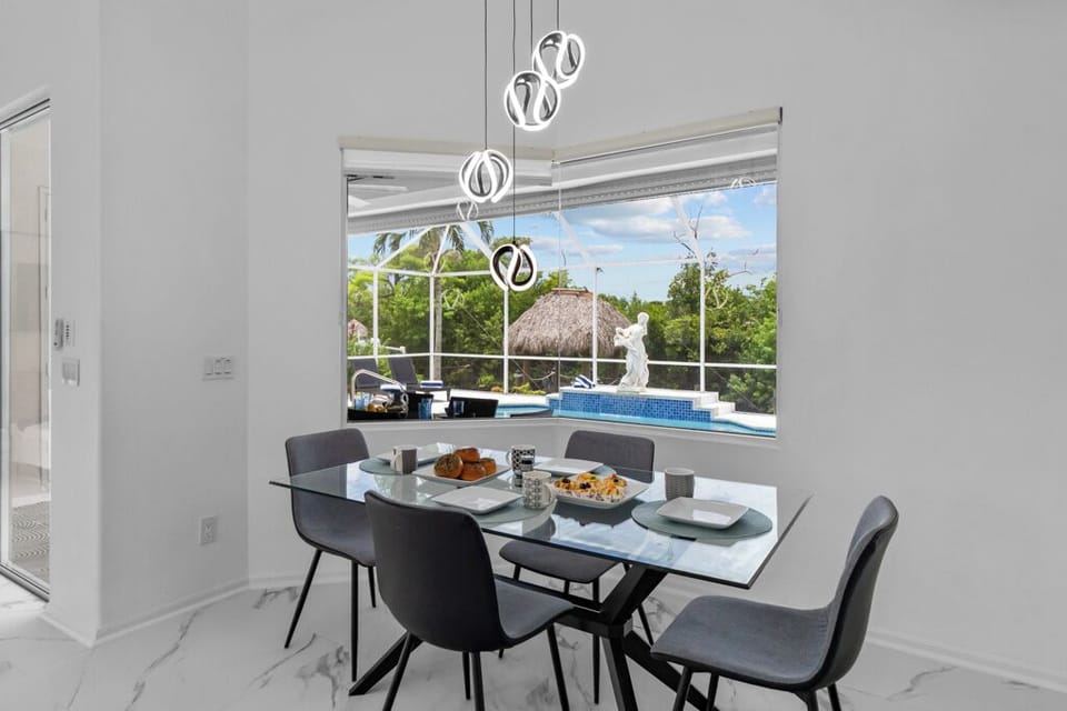 Cozy breakfast nook overlooking the sparkling pool—enjoy morning coffee with a view or casual meals in sunlit comfort