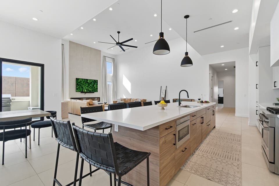 Fully equipped kitchen featuring a large kitchen island offering an abundance of counter space with bar seating, high-end stainless steel appliances, and stocked with all culinary essentials.