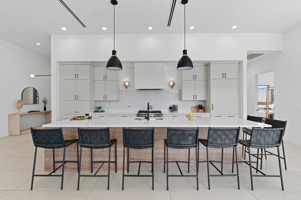 Fully equipped kitchen featuring a large kitchen island offering an abundance of counter space with bar seating, high-end stainless steel appliances, and stocked with all culinary essentials.